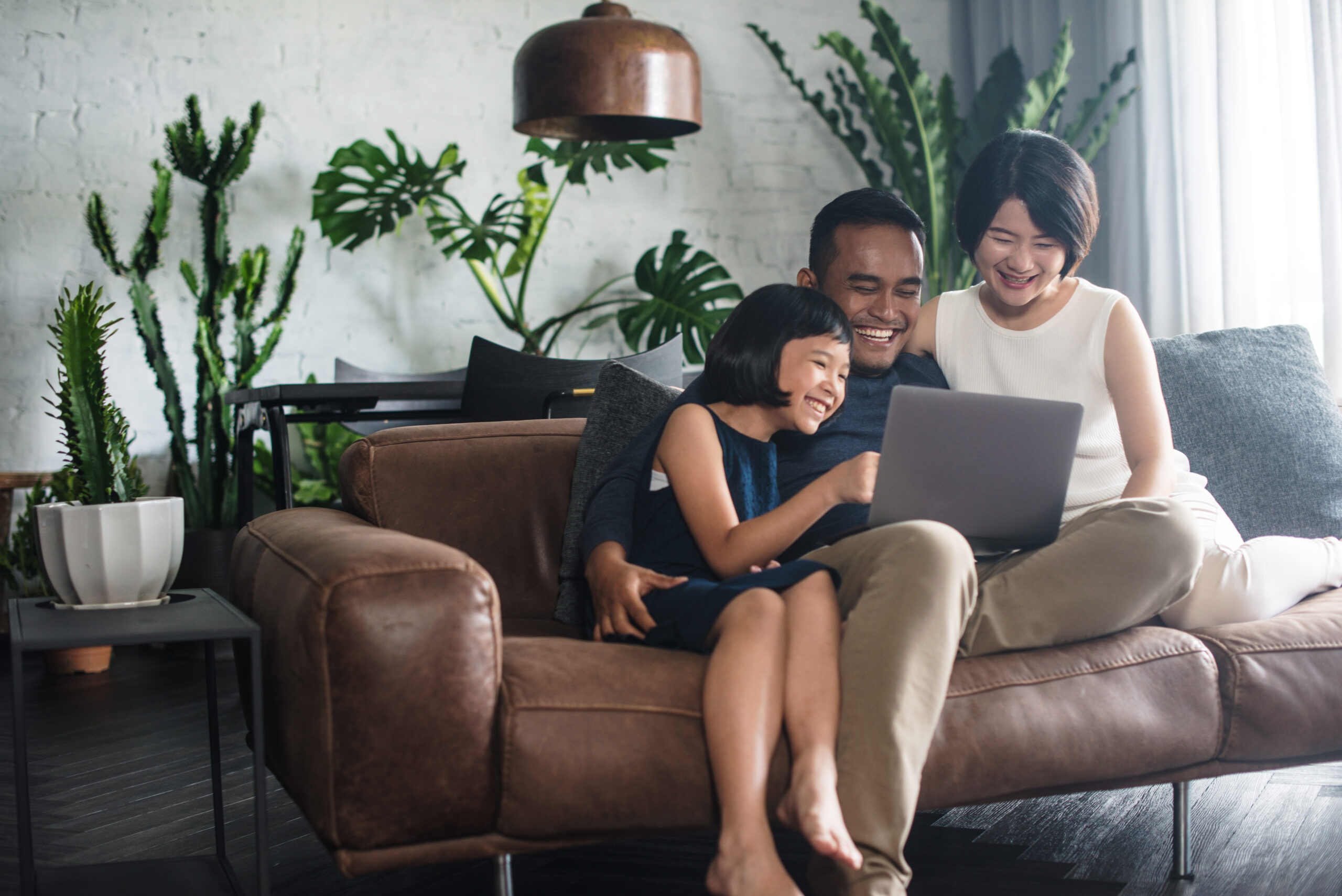 Young,Asian,Family,Looking,At,The,Laptop,Together,At,Home.